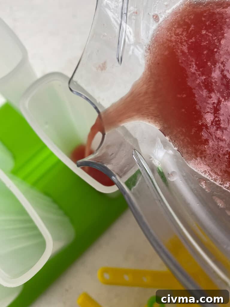 Homemade Watermelon Popsicles Recipe 5 process of pouring watermelon mixture into mold