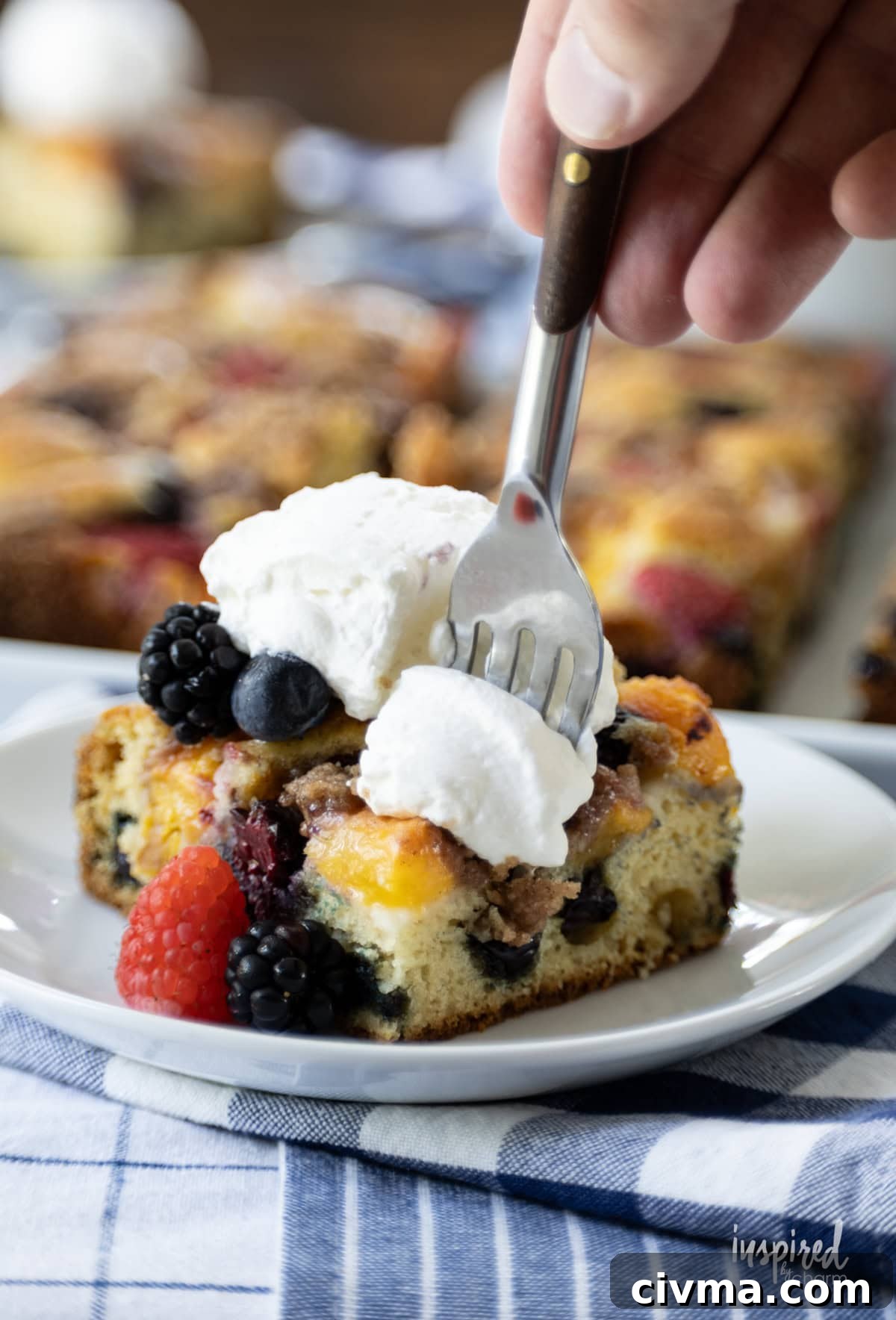 fork taking a bite of Nectarine and Berry Buckle on a plate.