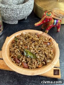Sesame rice (Ellu Sadam) served in a wooden bowl, garnished with spices and herbs.