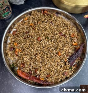 Traditional sesame rice dish with spices and nuts in a stainless steel bowl.