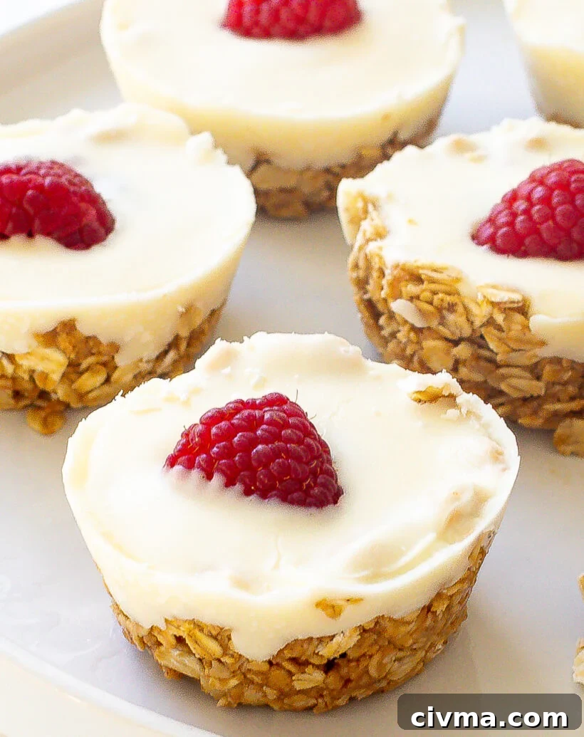 White chocolate oat cup with a raspberry on top served on a white plate.