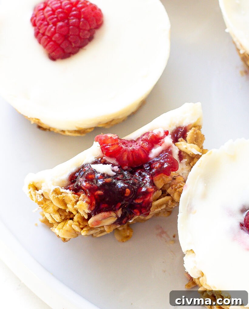 White chocolate oat cup cut in half showing layers of oats, jam and white chocolate.