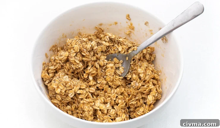 Oat mixture mixed in a white bowl with a spoon.