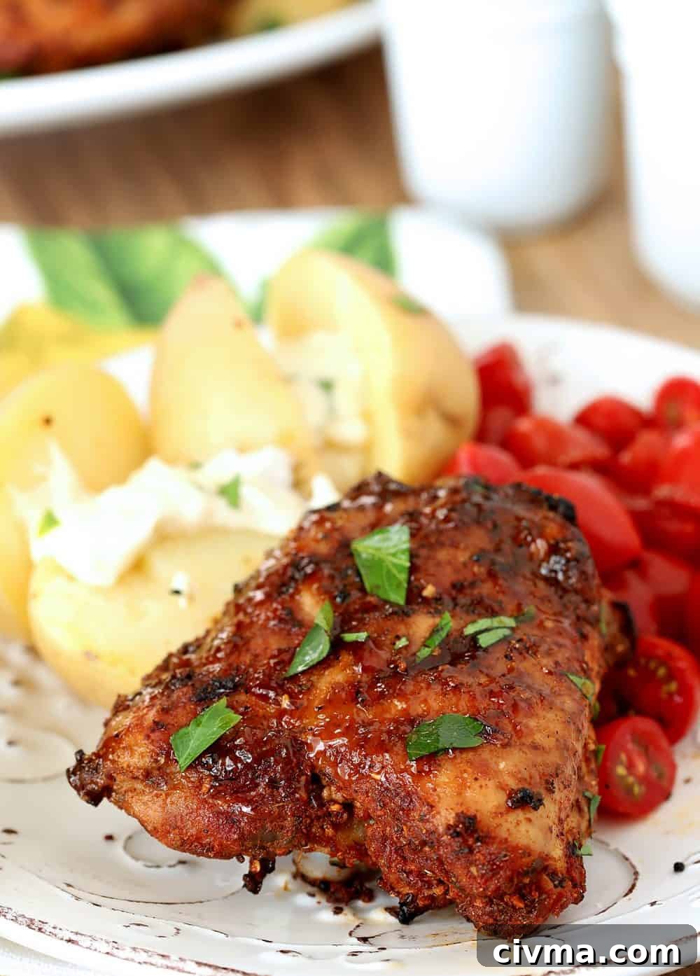 Individual serving of Spanish Tapas Chicken Thighs served with potatoes and tomatoes.