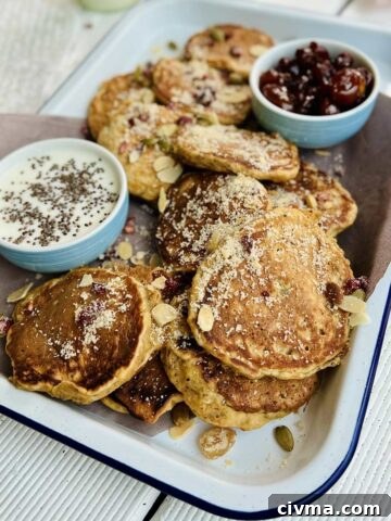 Butternut squash pancakes on white tray with the blue dream with two serving dishes, one with jam, one with yoghurt and chia seeds sprinkled over