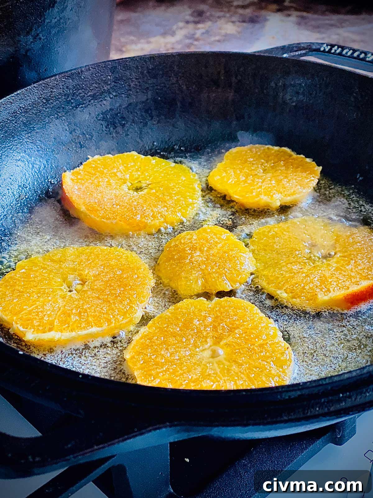 Dutch Baby Pancake Recipe for a Puffy Oven Pancake 8 Orange slice cooking in butter for dutch baby pancakes
