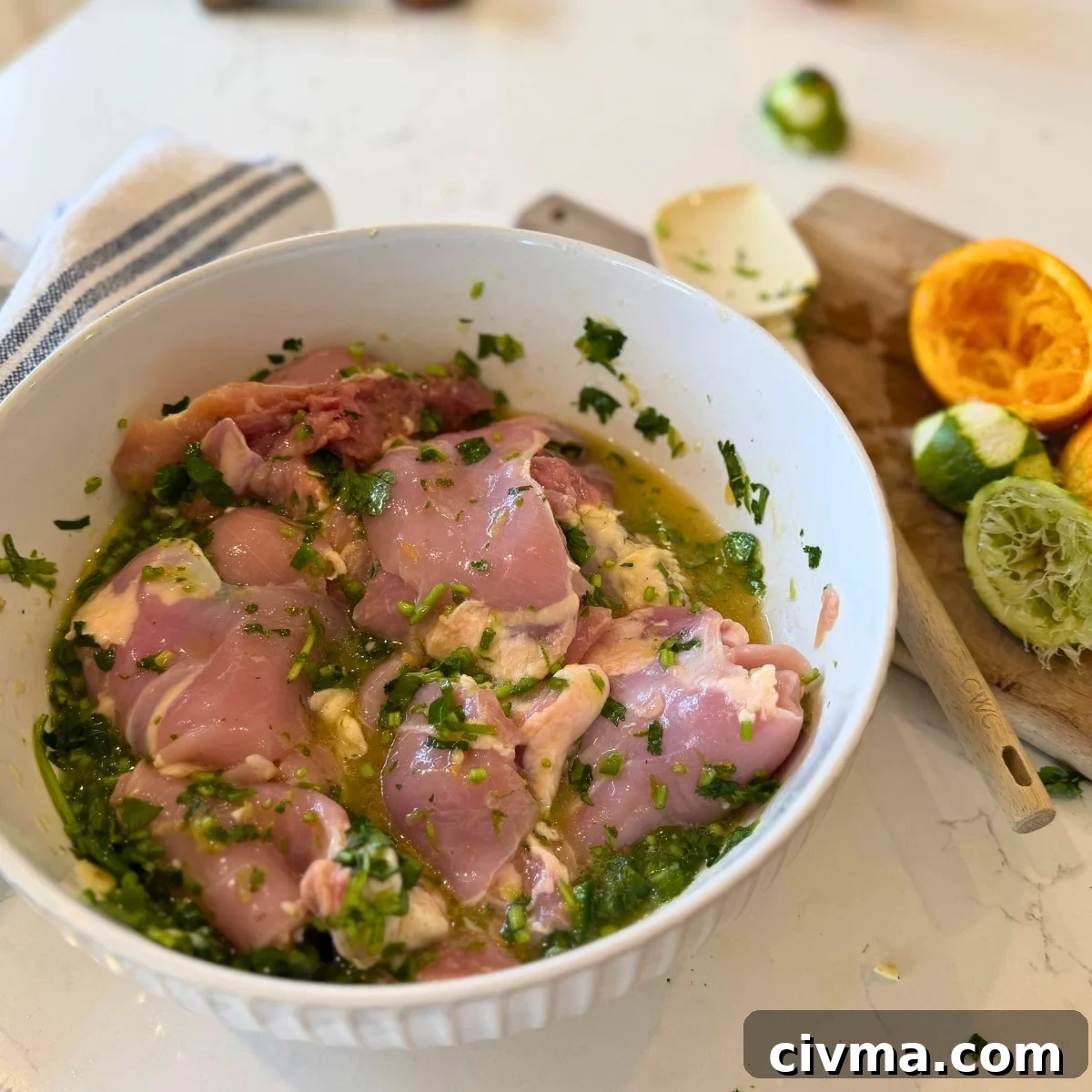 marinating chicken thighs in citrus marinade in a bowl