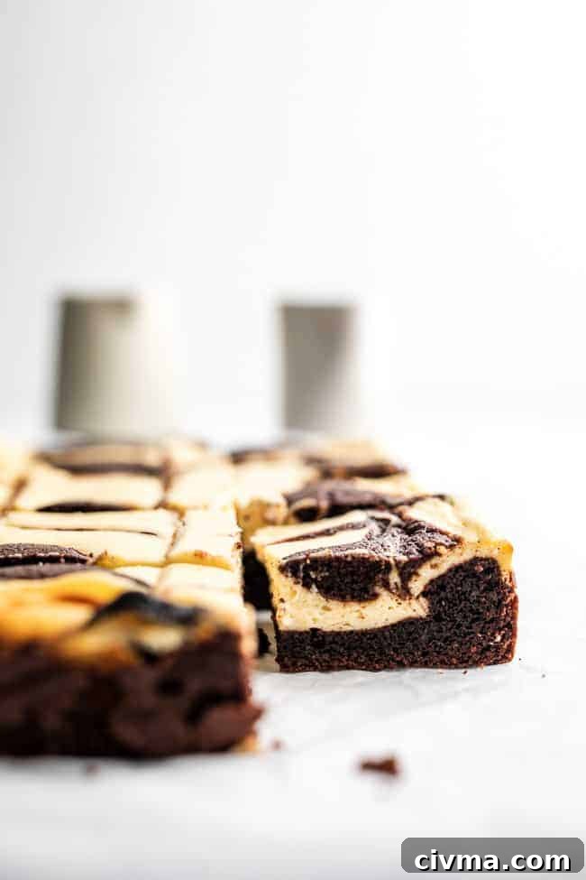 Keto Cheesecake Brownies Recipe 3 cheesecake brownie on parchment paper with bottles in background
