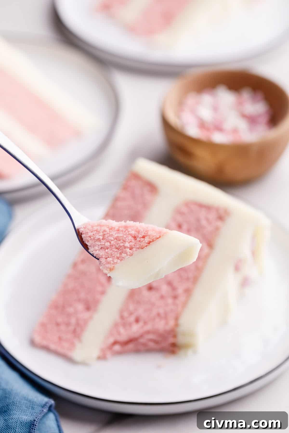 close up of a bite of pink velvet cake sitting on a silver fork.