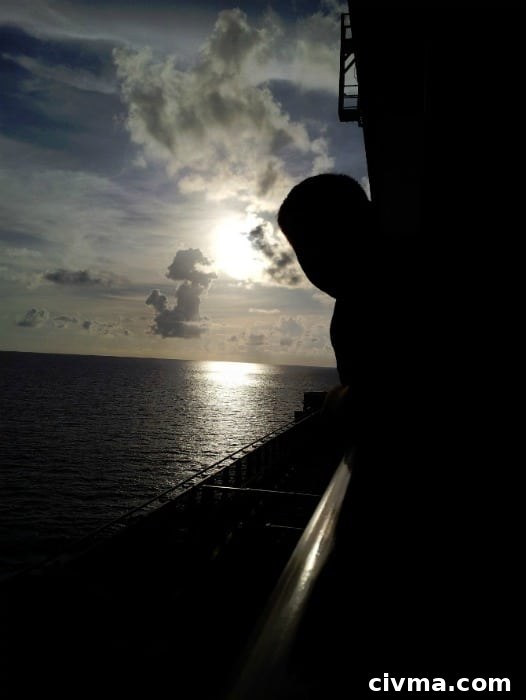 john leaning out over the side of the balcony at sunset