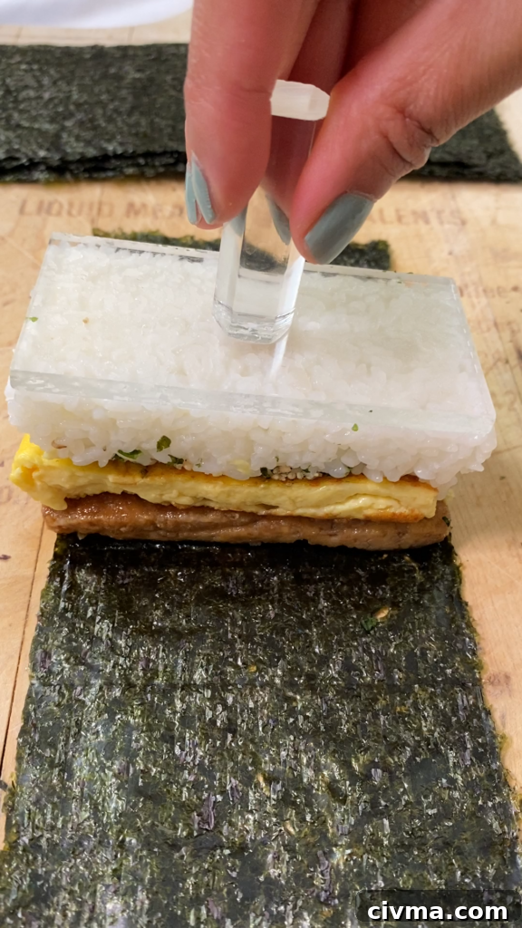 Layering tofu and rice for vegan musubi