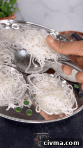 Steamed idiyappam being removed from the plate.