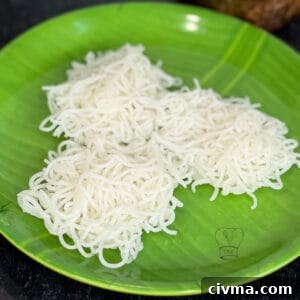 Freshly made idiyappam noodles on a green banana leaf, traditional South Indian breakfast.