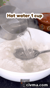 Pouring hot water into rice flour for making idiyappam dough.