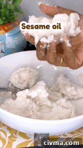 Hand applying sesame oil to idiyappam dough for soft, flavorful nool puttu.