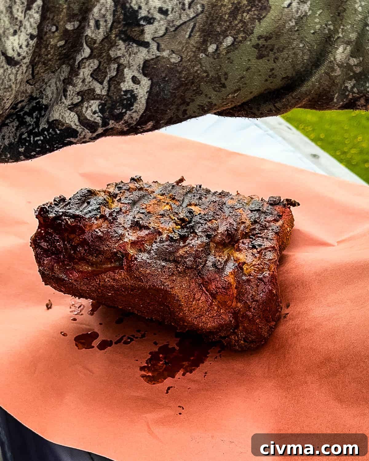 The pork roast placed on peach butcher paper.