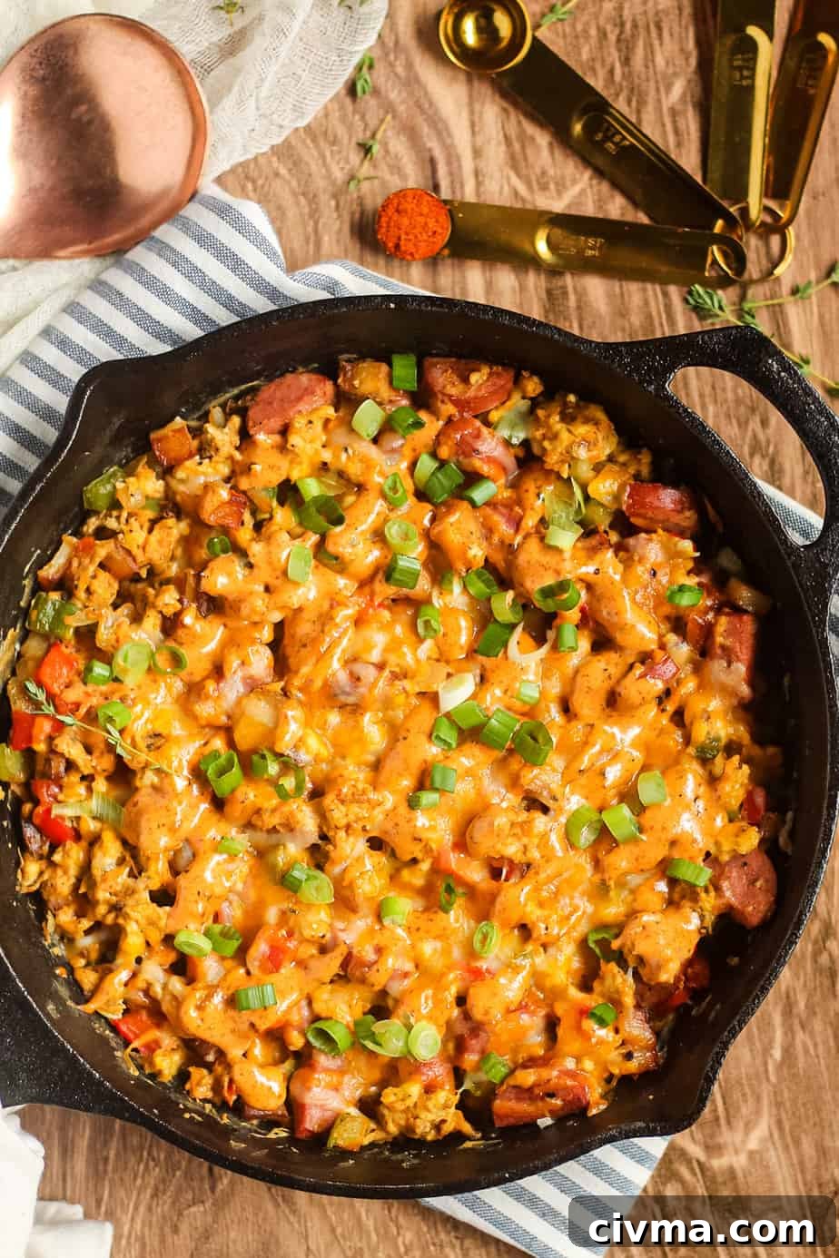 Overhead shot of a loaded Creole breakfast skillet on a wooden surface.