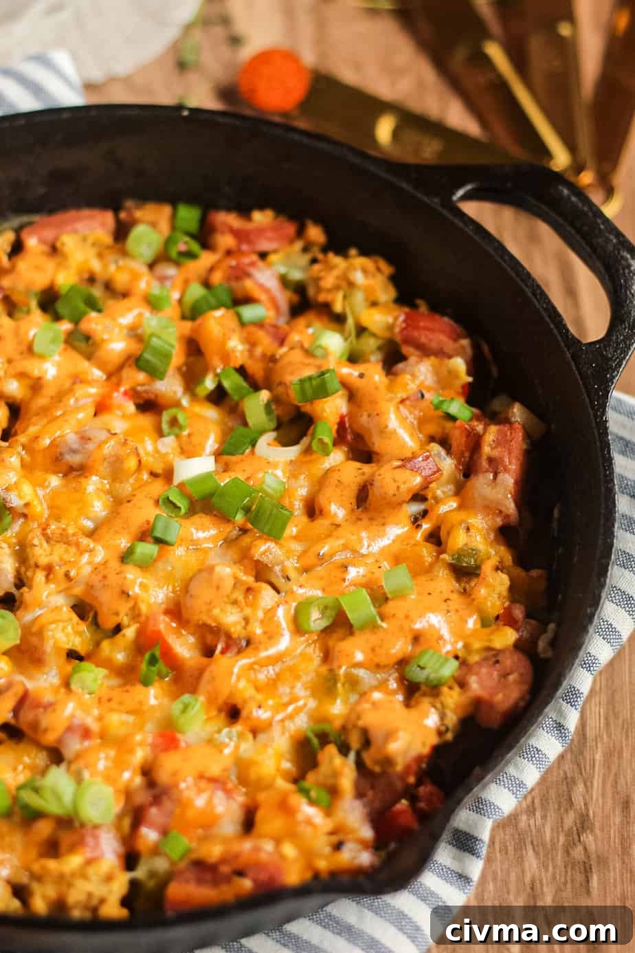 Angled shot of a loaded Creole breakfast skillet on a wooden surface.