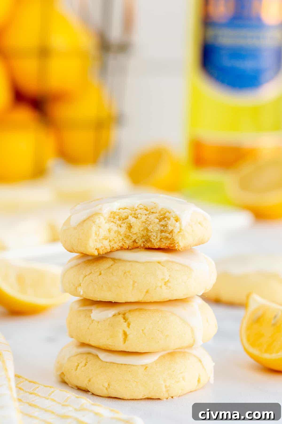 A stack of lemon cookies with a bite missing from the one on top.