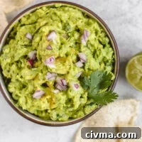 overhead view of guacamole in a serving bowl with chips sprinkled on the side
