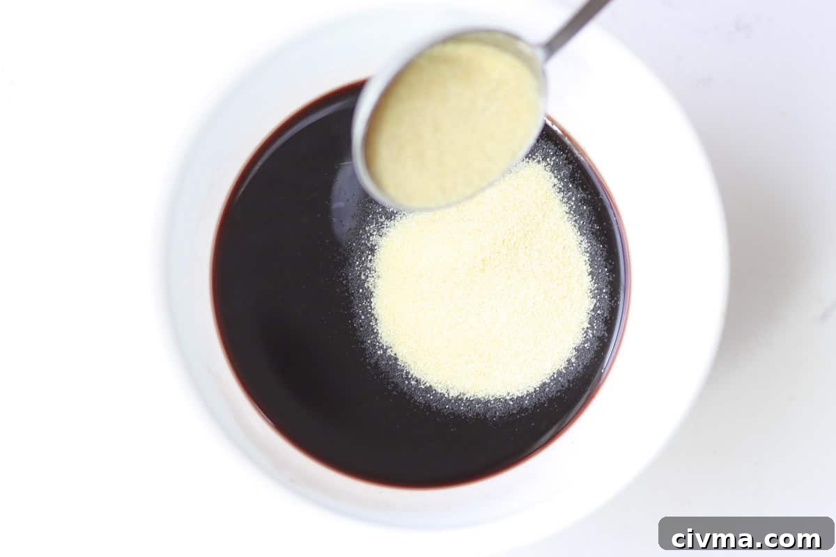 gelatin powder being added to elderberry syrup