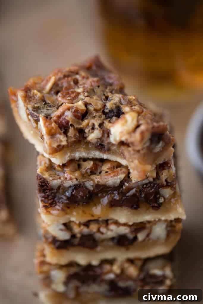 stacked chocolate pecan pie bars, top one has a bite taken out