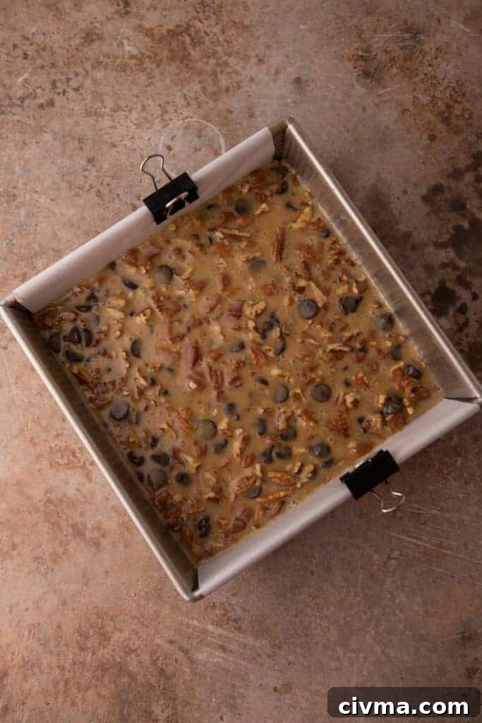raw chocolate pecan pie bars in the baking dish before going into the oven