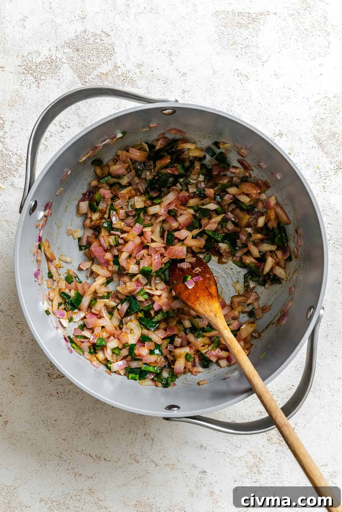 Process shot showing stirring ingredients in a pot.