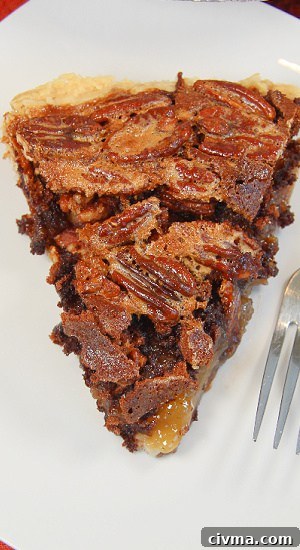 A delicious piece of dessert with a sweet center filling, crunchy nuts, and a buttery crust.