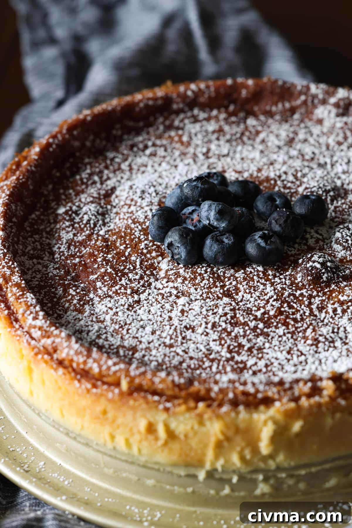 Flourless white chocolate cake dusted with powdered sugar and garnished with fresh blueberries.