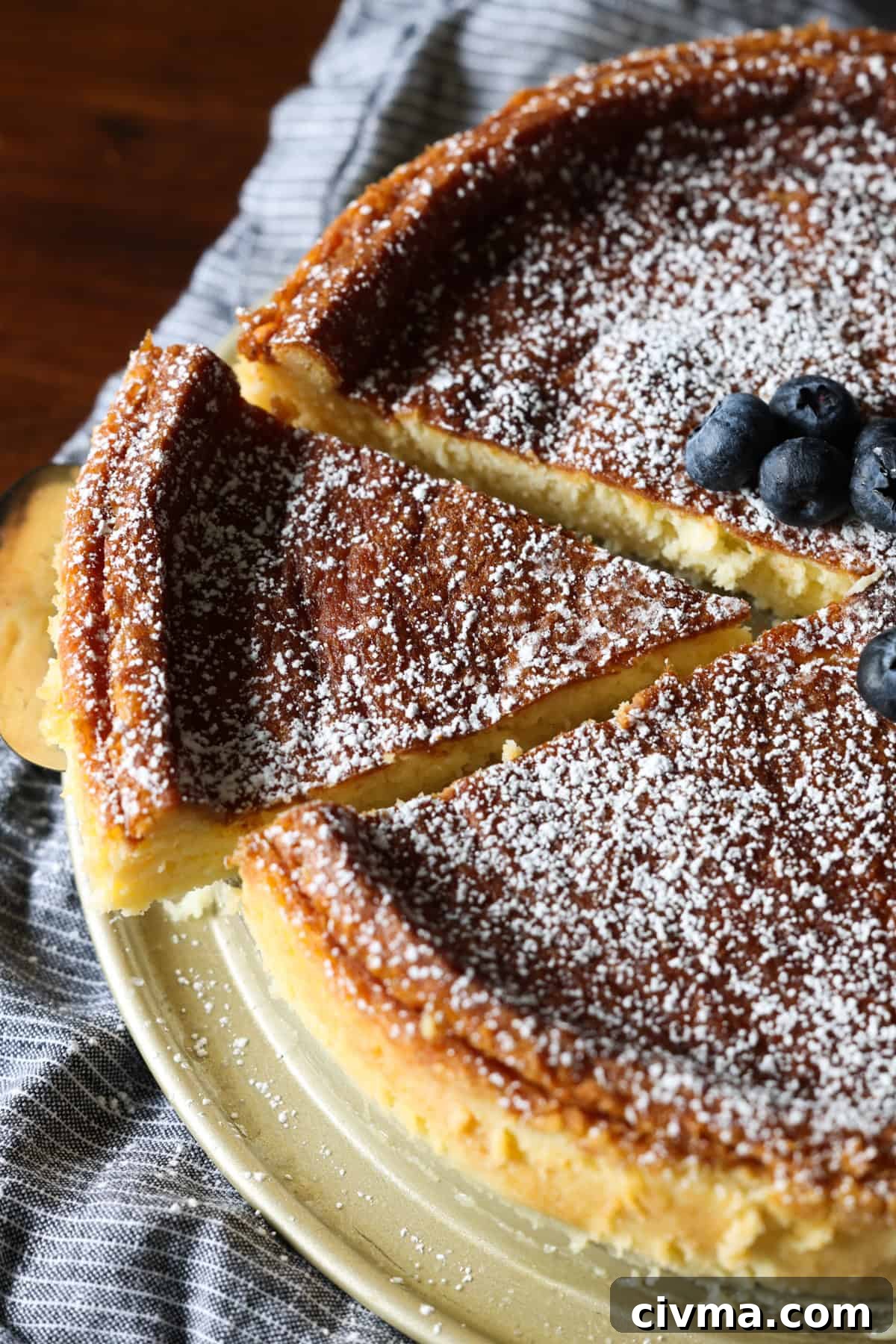 Overhead view of a slice being cut and lifted from a flourless white chocolate cake.