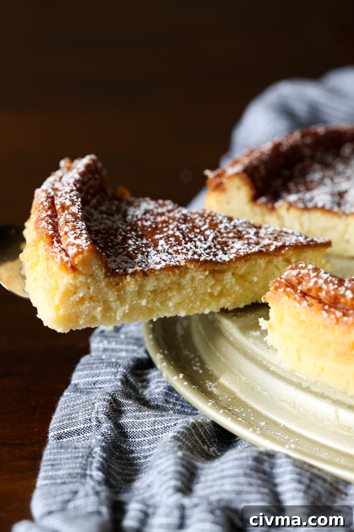 A slice is lifted from a flourless white chocolate cake.