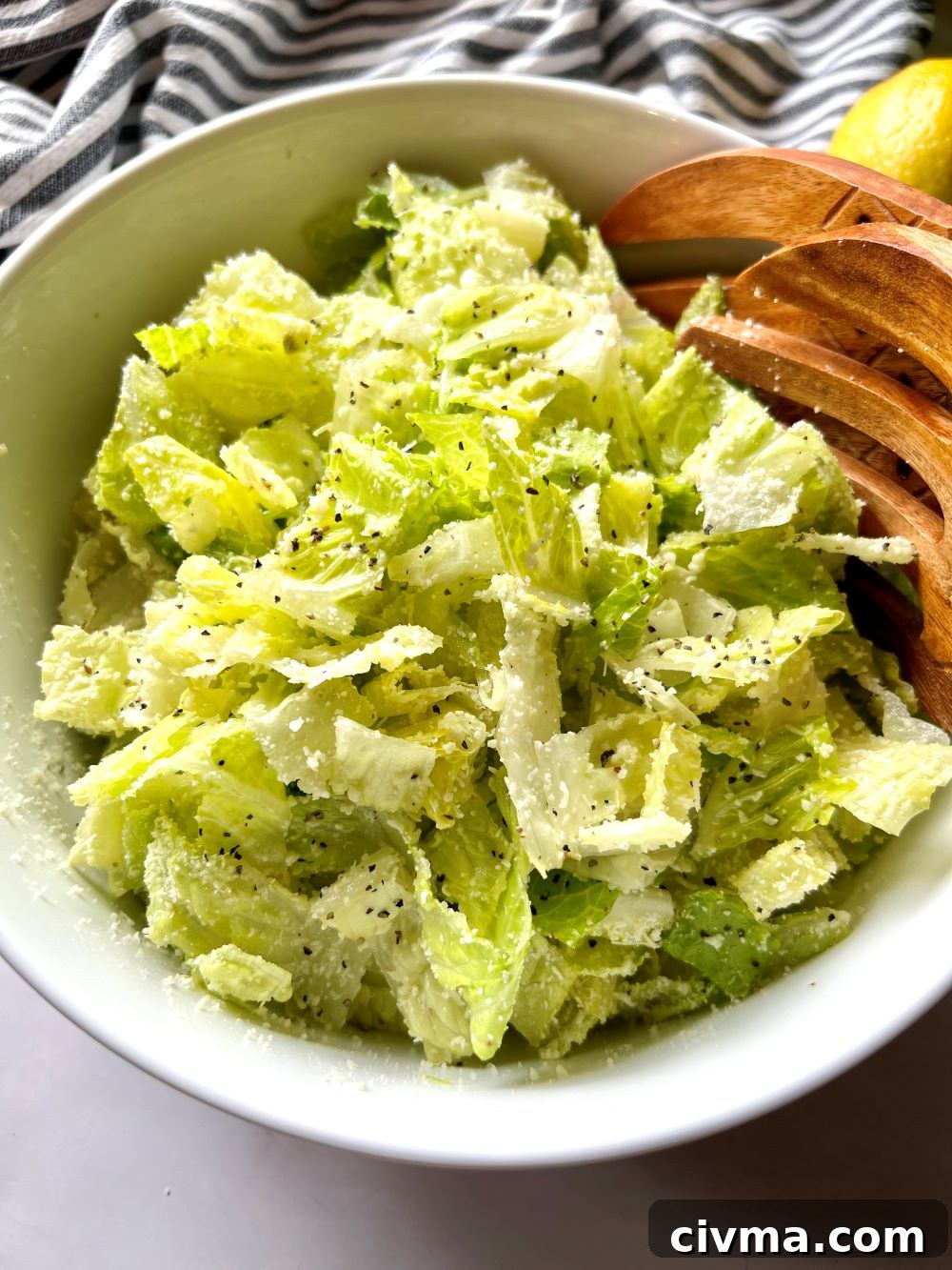 Four Ingredient Crunchy Lemon Parmesan Salad 2 Serving bowl with crunchy lemon parmesan salad and serving tongs.