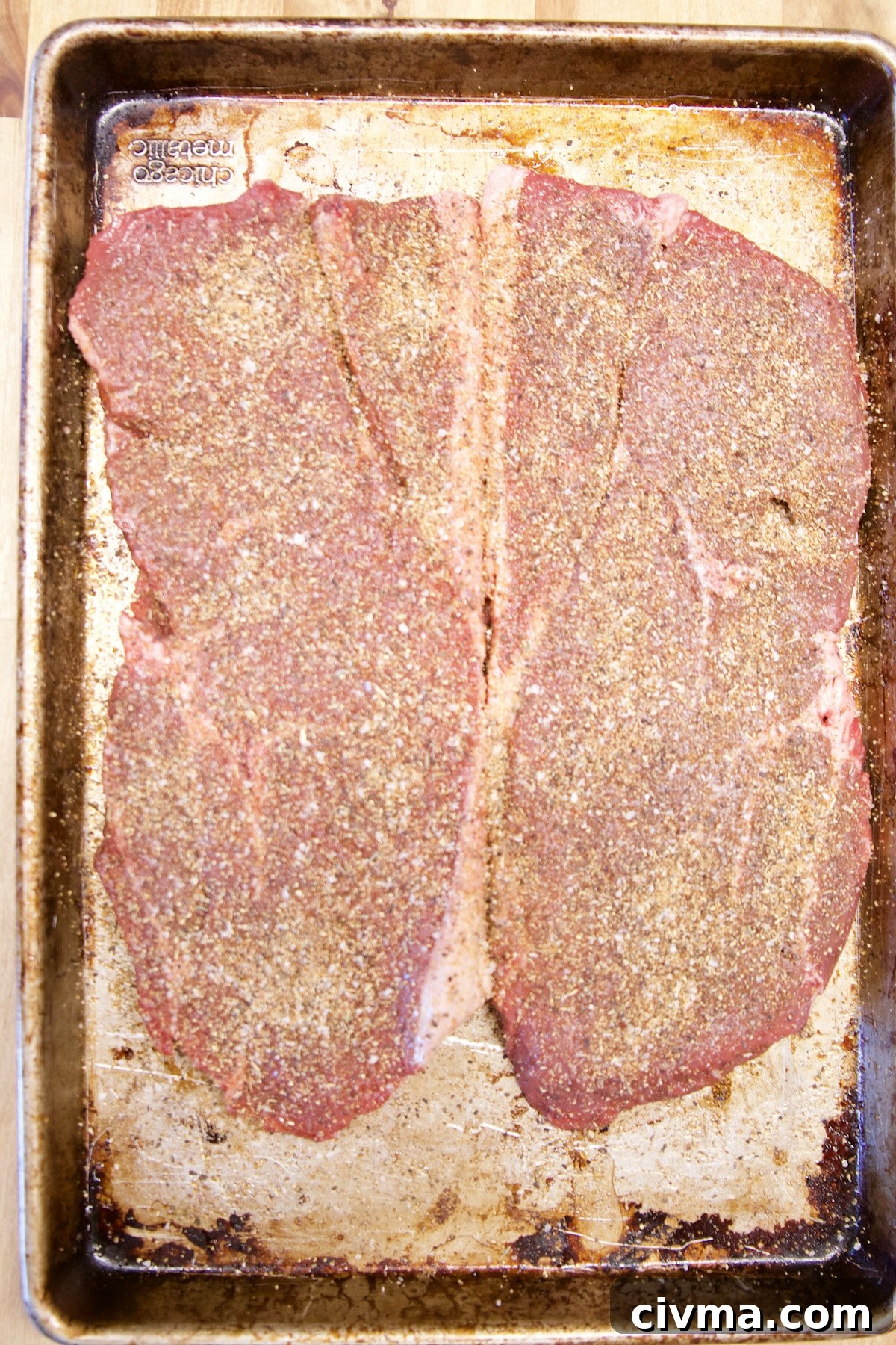 Grilled sirloin steak for cheesesteak sliders. 2 Sirloin steaks coated in steak rub.