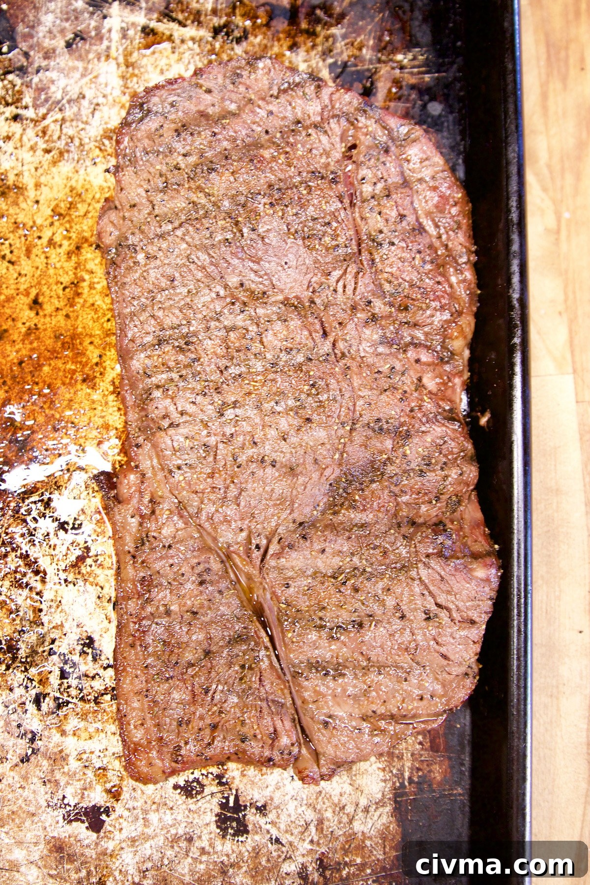 Sirloin steak sliders. Grilled steak resting on a rimmed baking sheet.