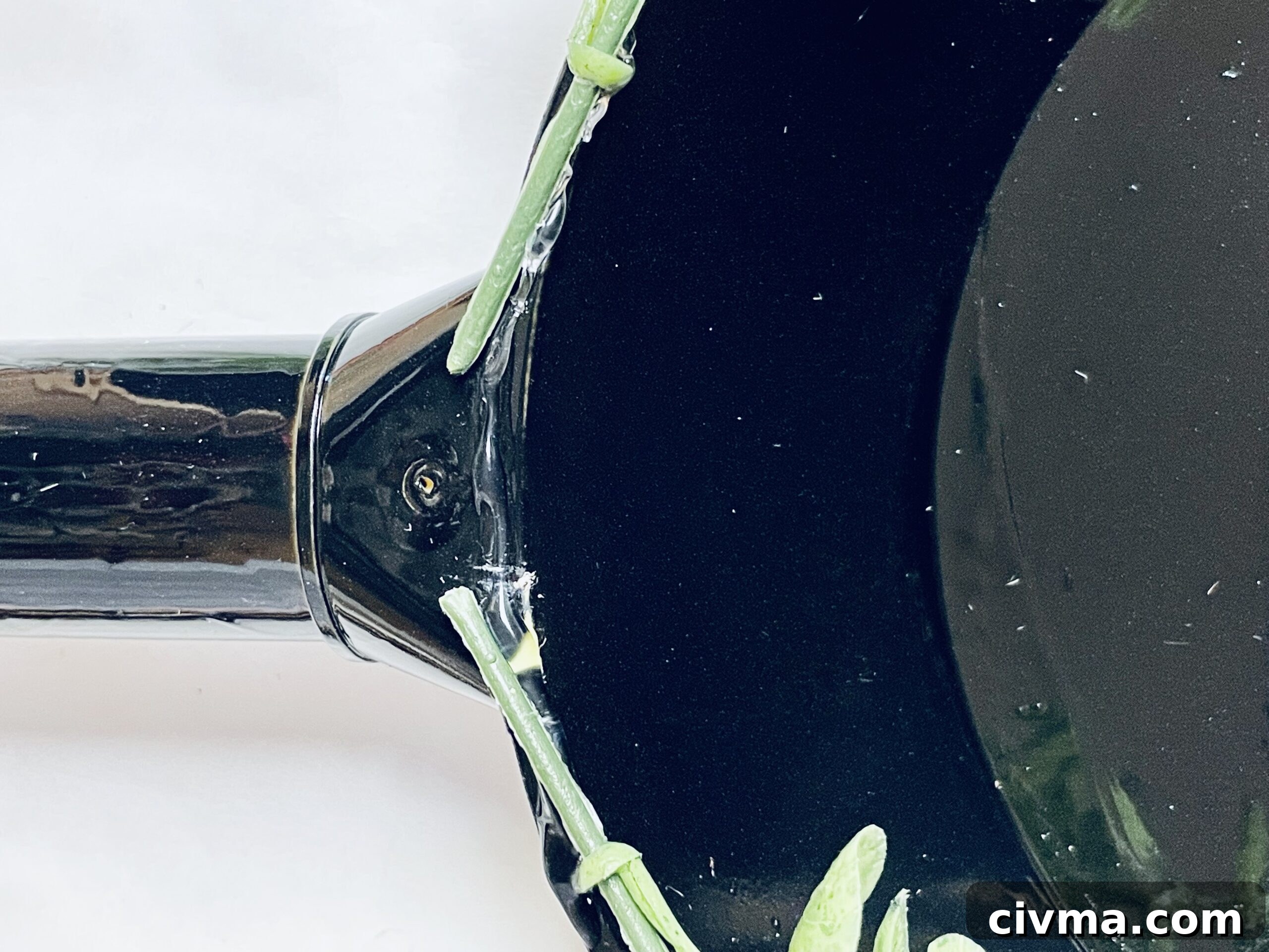Faux eucalyptus being attached to a painted plastic shovel