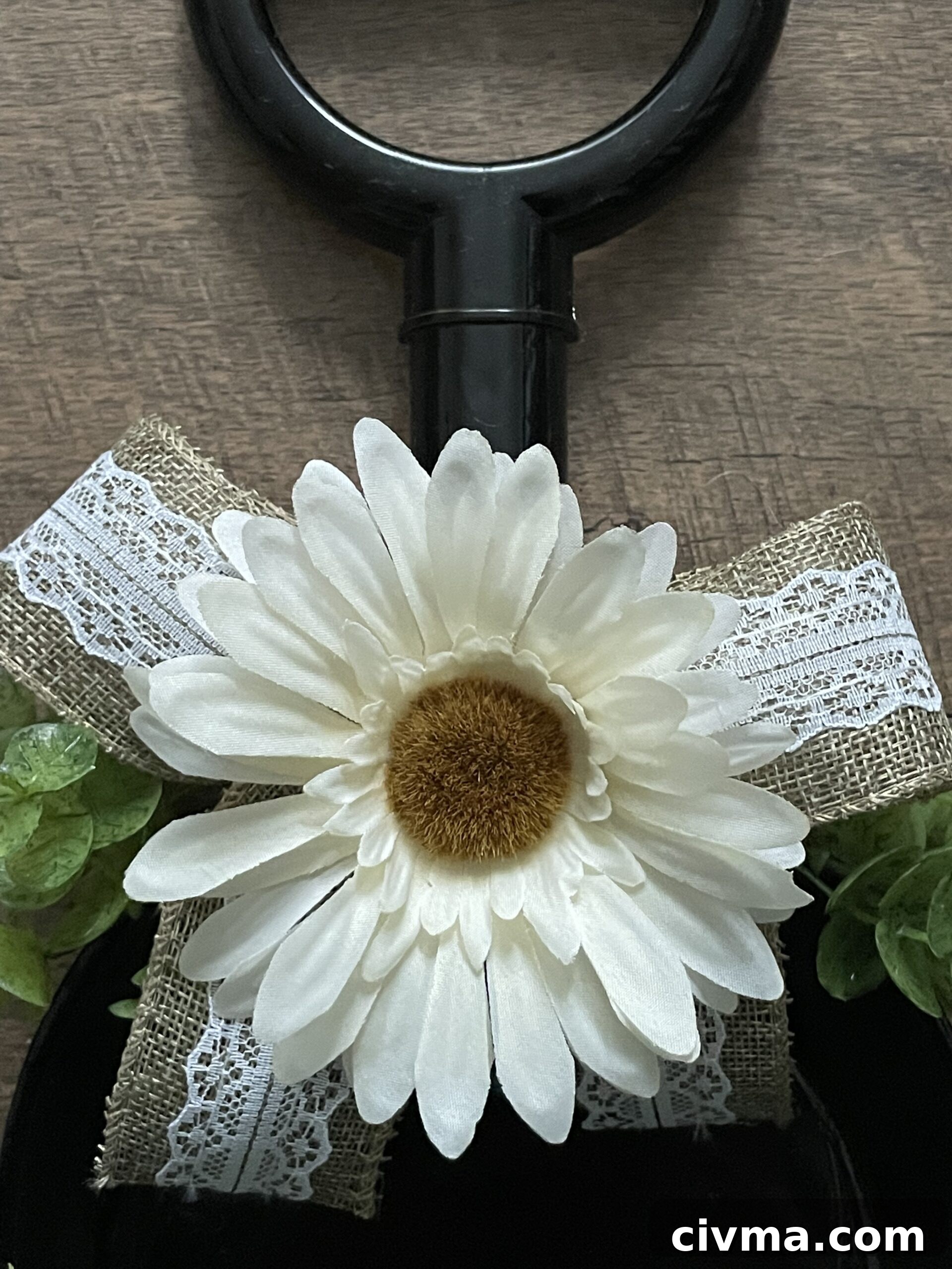 White gerber daisy added to a burlap bow on a farmhouse wreath