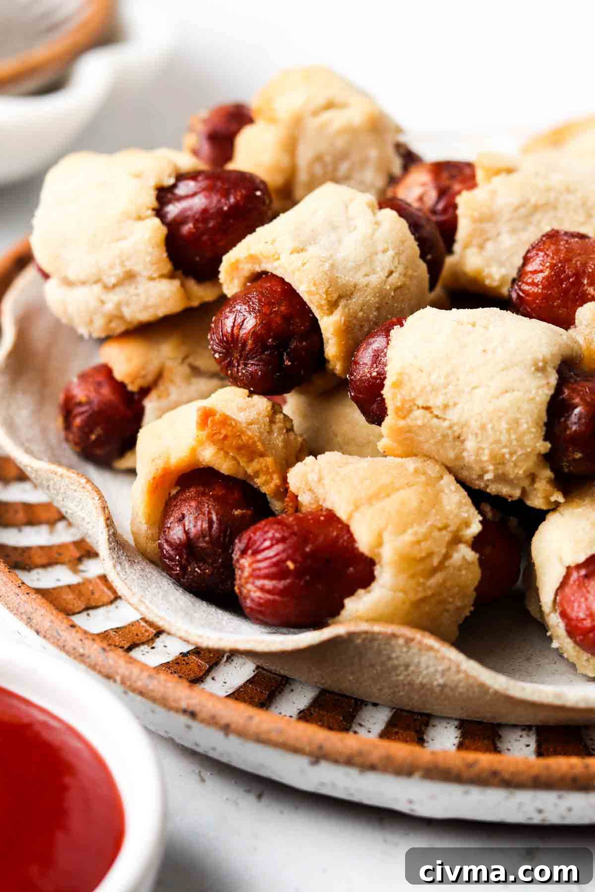 Gluten free pigs in a blanket piled on a plate.