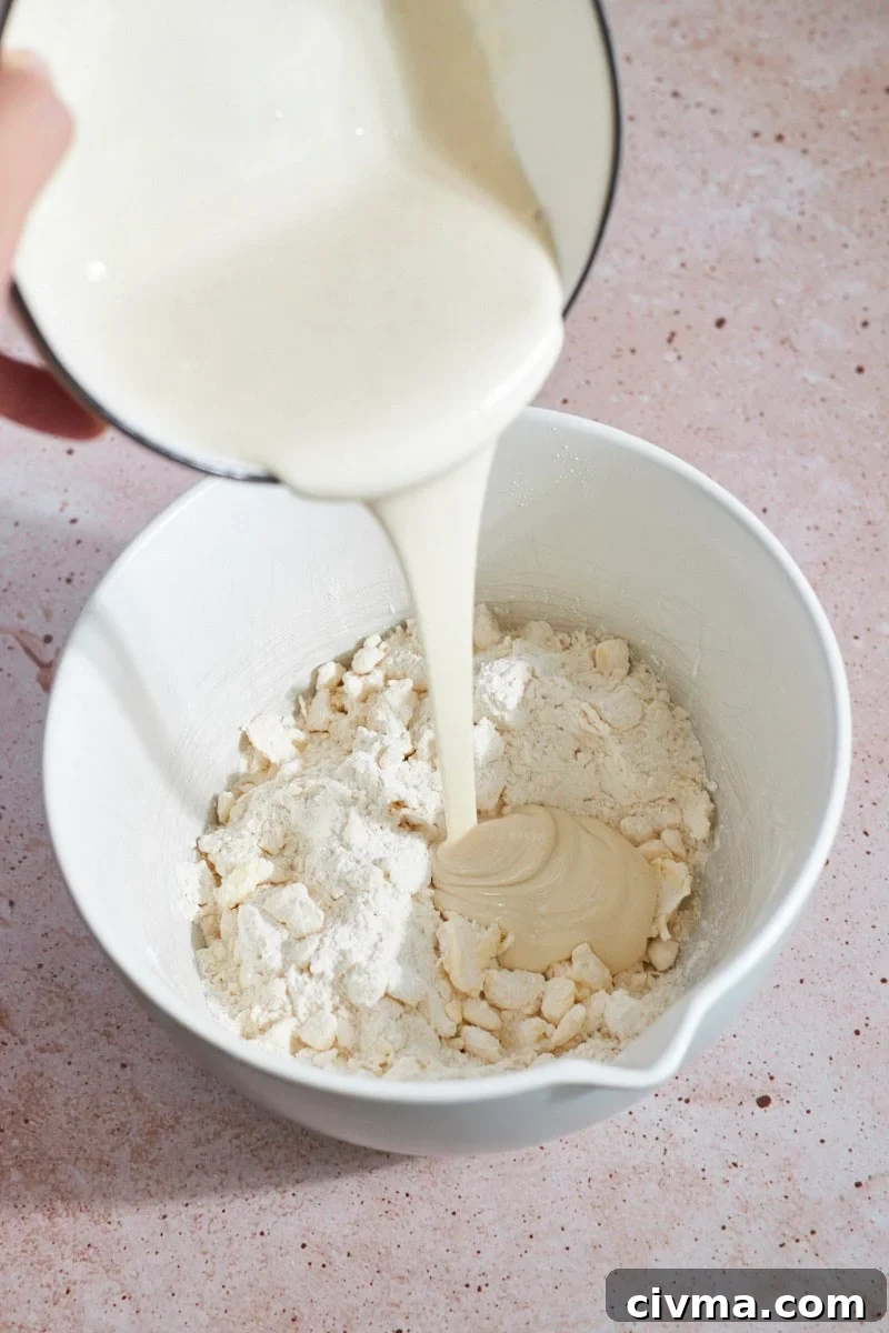 Sourdough discard mixture being poured into the mixing bowl.