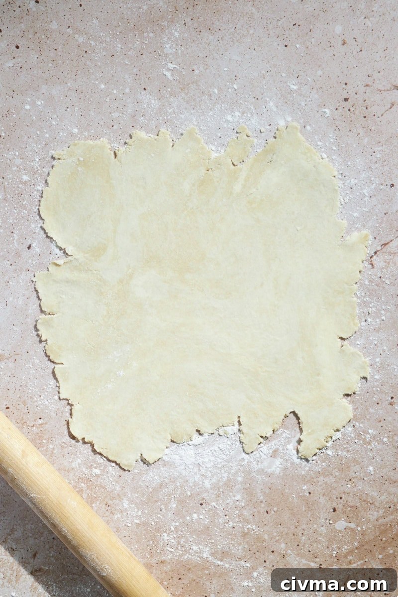 Crust rolled into a rough circle on a work surface.