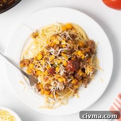 Plate of Mexican Spaghetti topped with shredded cheese.
