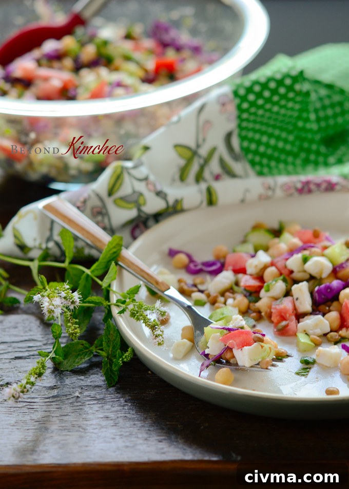 Chickpea lentil salad on a serving dish with a fork.