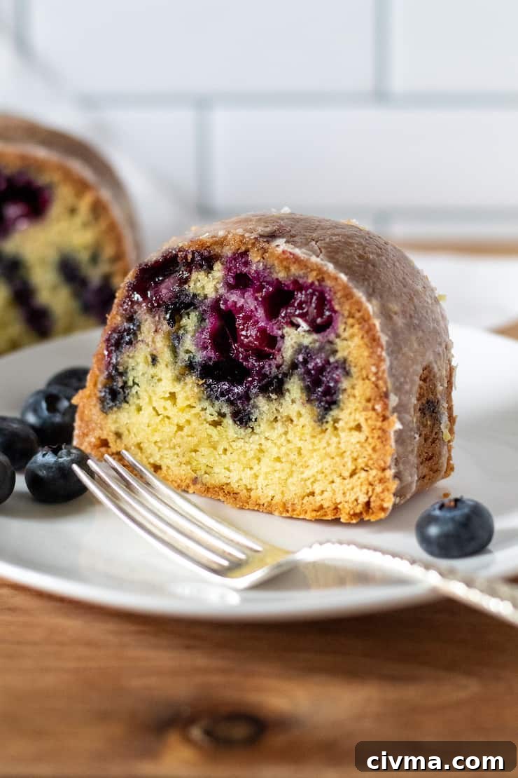 Slice of blueberry lemon Bundt cake on serving plate.