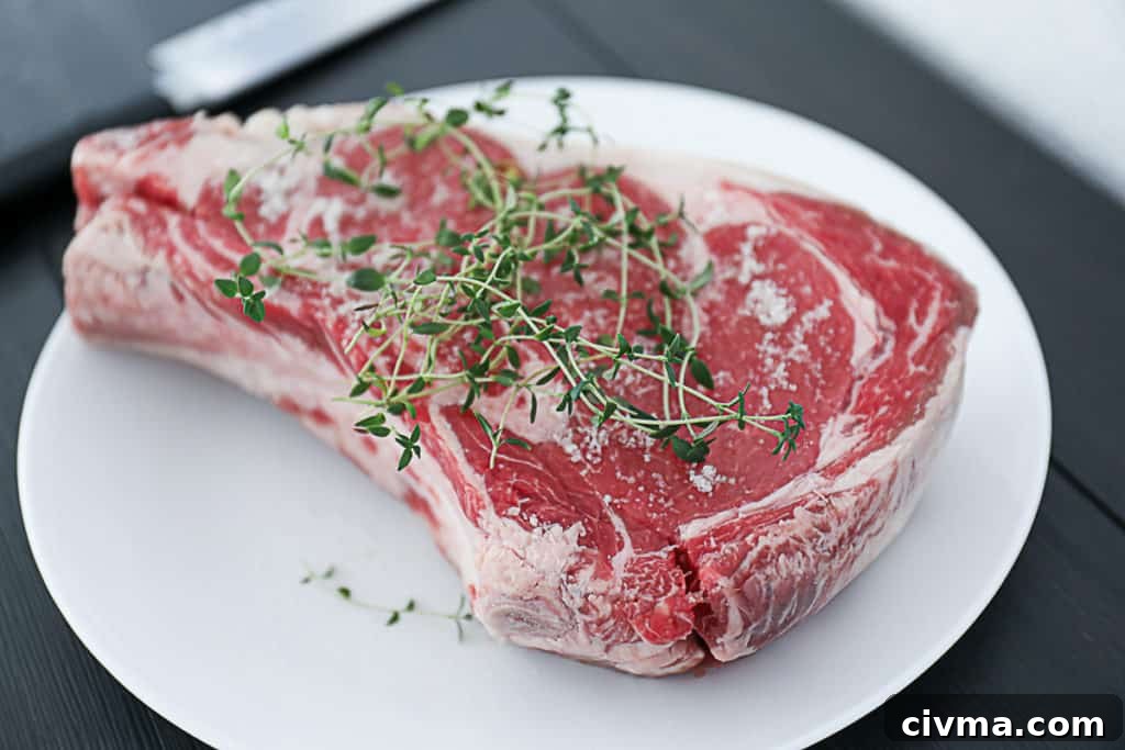 How to Smoke Meat at Home: A Beginner's Guide 3 Side shot of Raw Prime rib with thyme on a plate.