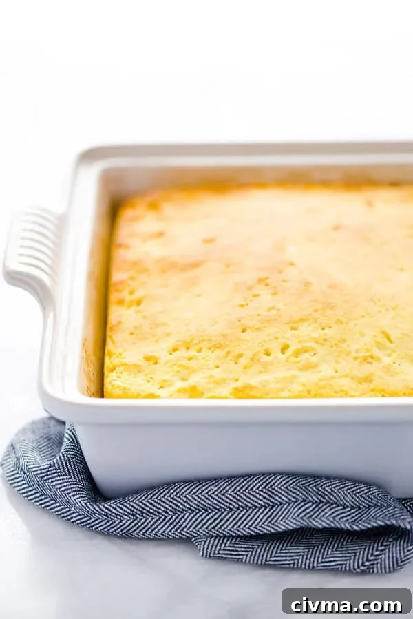 A fully baked gluten free sourdough cornbread recipe still in the pan on top of a blue towel