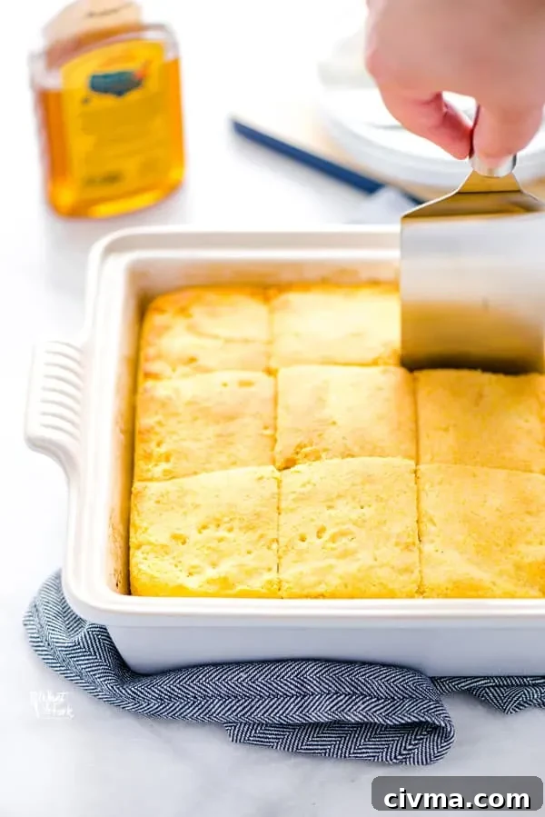 A gluten free sourdough cornbread recipe being cut with a square spatula/server