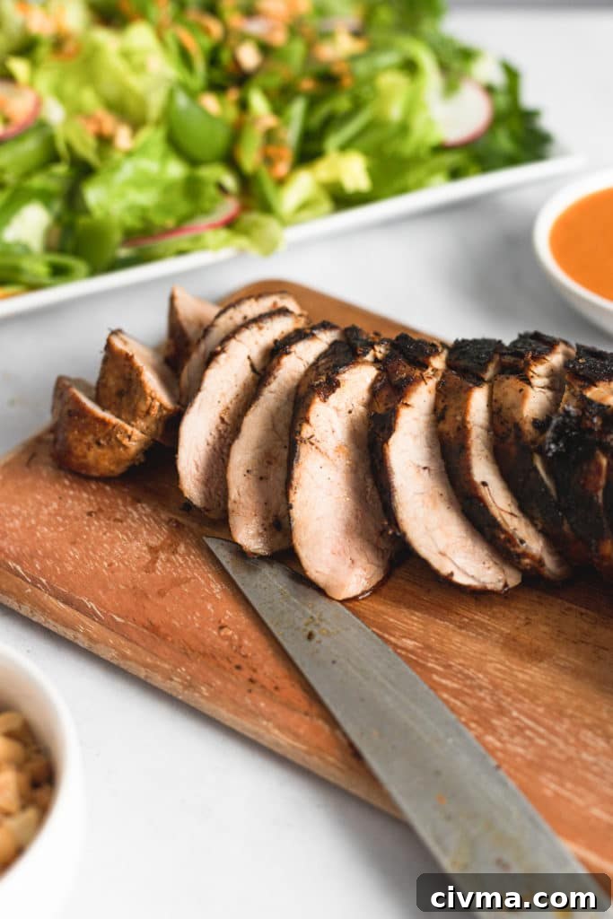 Gochujang Pork Tenderloin Salad with Snap Peas and Peanuts (GF) 5 Grilled pork tenderloin sliced on a wooden cutting board.