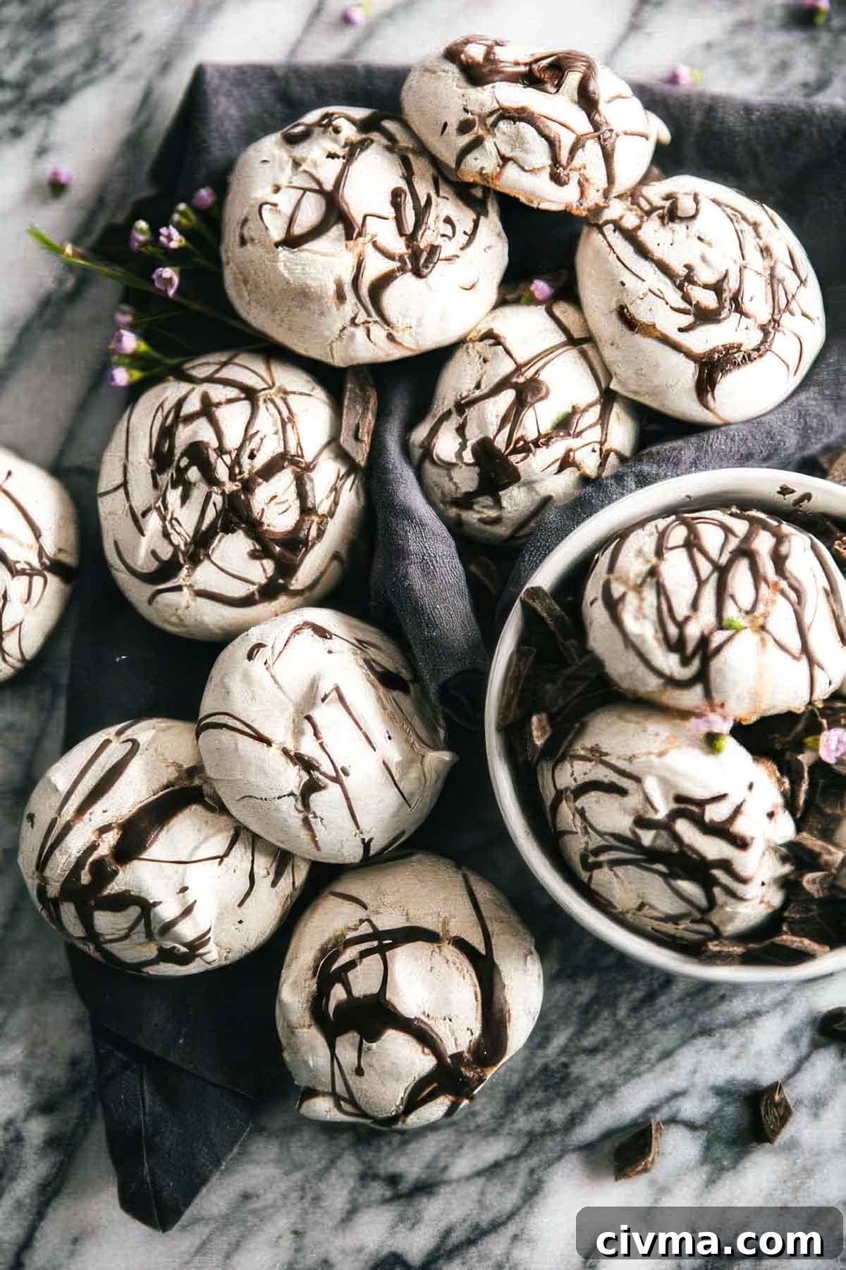 Dark Chocolate Swirl Meringue Cookies 2 a white bowl filled with swirled chocolate meringue cookies with more cookies on a linen towel on the table around the bowl