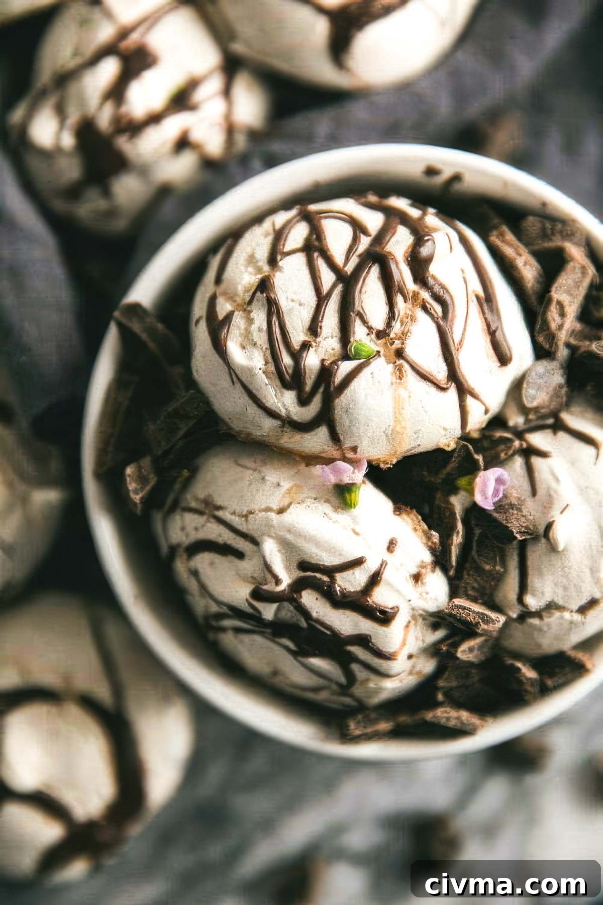 Dark Chocolate Swirl Meringue Cookies 3 a white bowl filled with swirled chocolate meringue cookies with more cookies on the table around the bowl
