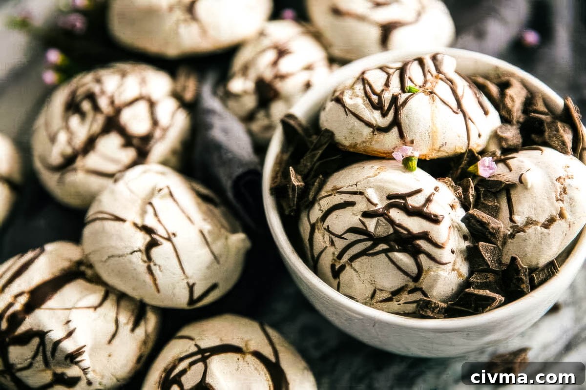 Dark Chocolate Swirl Meringue Cookies 4 a white bowl filled with swirled chocolate meringue cookies with more cookies on a linen towel on the table around the bowl